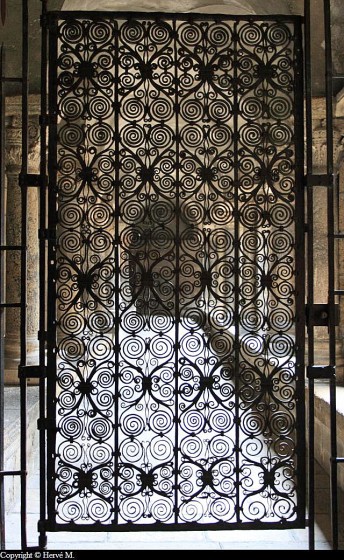Grille romane en fer forgé fermant la galerie ouest du cloître