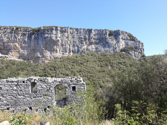 Un vieux pan de mur face à une falaise impressionnante