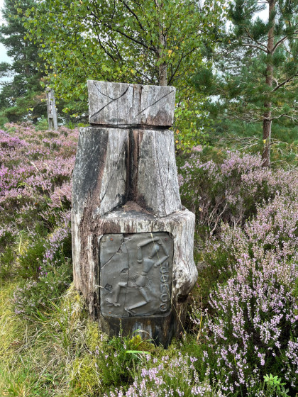 Sculptures en bois et plaque commémorative.