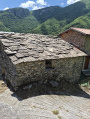 Maison en pierres plates et toit en ardoise.