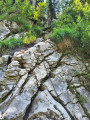 The rocky slab with chain and staples leading down to the torrent