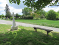 Une croix et un banc à l'entrèe de Bréançon