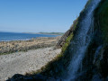 Waterfall cascading down to the shingle beach